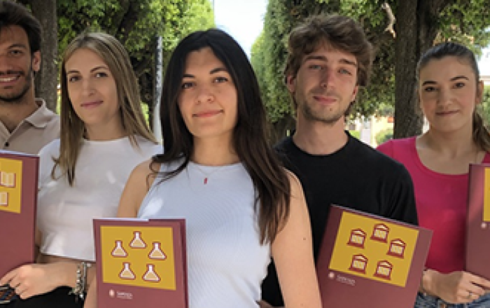 Gruppo di studenti che mostrano le loro tesi di laurea
