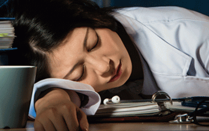 Un'operatrice sanitaria china la testa su un tavolo per dormire