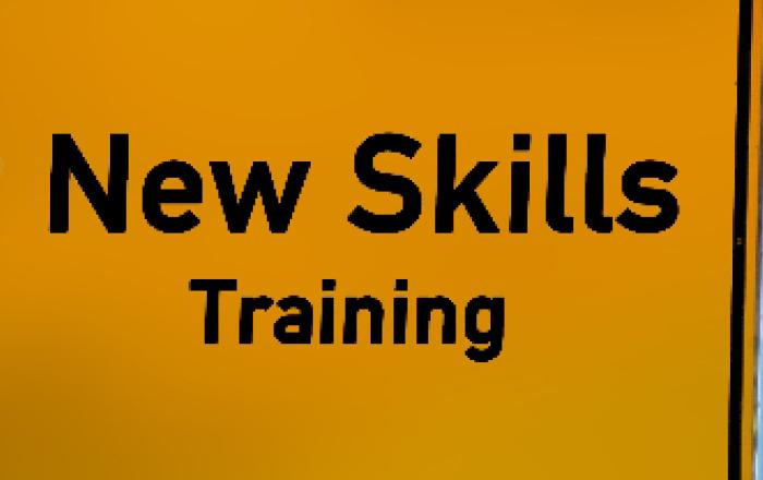 Un cartello stradale con testo "New Skills training"